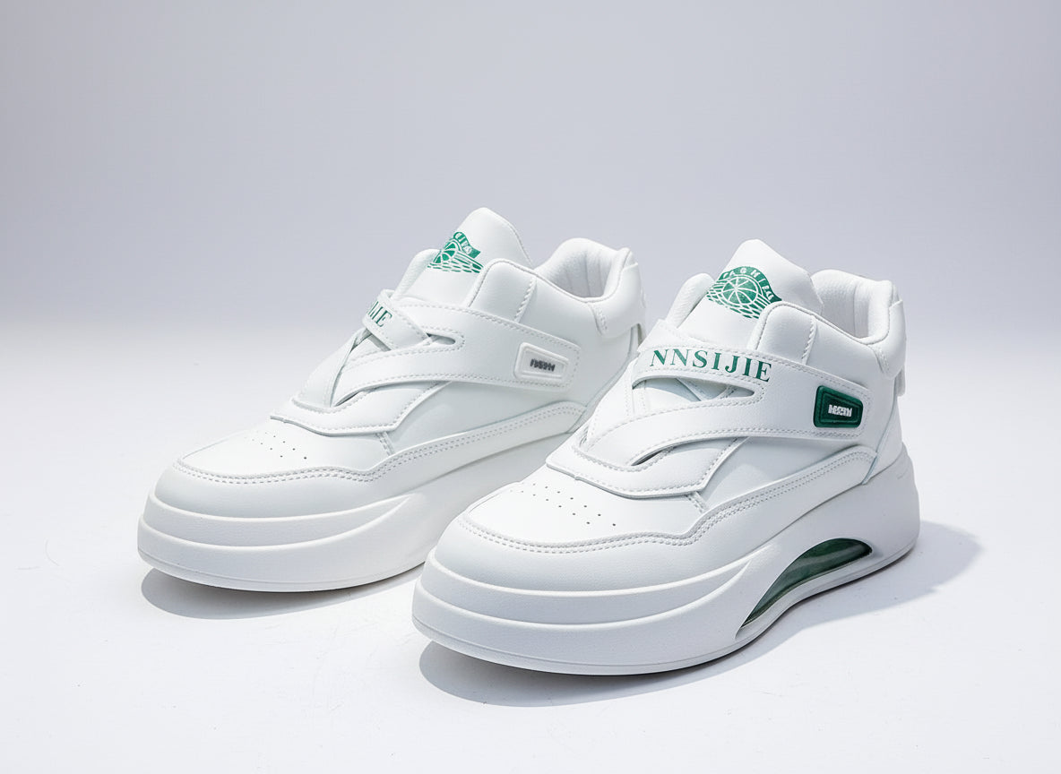 White sneakers with green accents on a gray surface with a red 'Fashion Casual Shoes' box in the background.